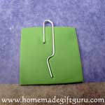 Press paper clip down gently and sandwich between key chain layers...